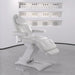 Bellucci Triple-Motor Electric Treatment Chair Front Angled View With White Wall And Product Bottles Displayed In The Background