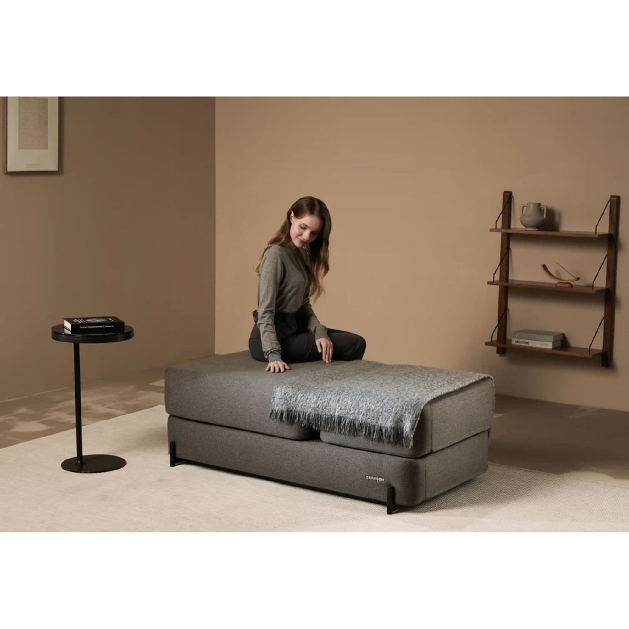 CERAGEM S4 Massage Lounger Gray Variant With Throw Blanket And Woman Sitting In Warm Modern Living Room