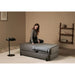 CERAGEM S4 Massage Lounger Gray Variant With Throw Blanket And Woman Sitting In Warm Modern Living Room