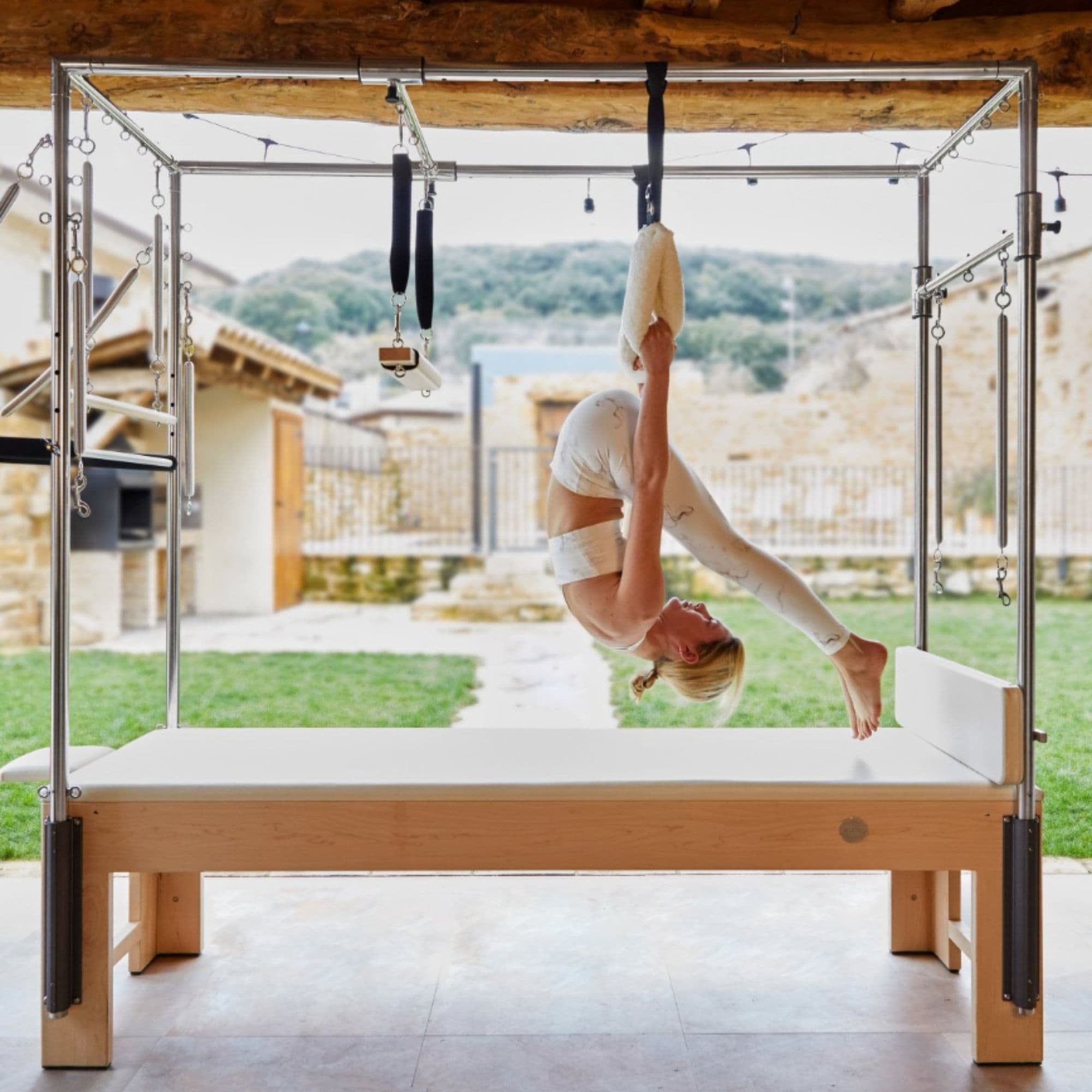 Cadillac Trapeze Bundle With A Woman Performing An Inverted Pilates Exercise In An Outdoor Setting