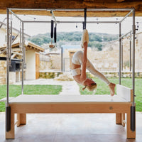 Thumbnail for Cadillac Trapeze Bundle With A Woman Performing An Inverted Pilates Exercise In An Outdoor Setting
