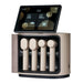 Ceragem MediSpa Pro Home Facial Device Massagers Stored In Their Charging Unit With The Touchscreen Display Above On White Background