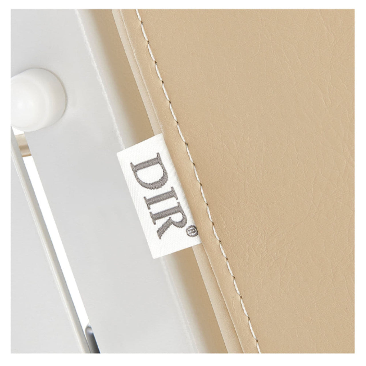 DIR Luxi 4-Motor Electric Spa Treatment Table Close-Up View Of Beige Upholstery With Brand Name And Stitching On White Background
