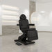 DIR Pavo 4-Motors Swivel Medical Spa Treatment Table Front Angled View Of Black Variant With Product Display Shelves And Brand Logo In The Background