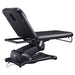 DIR Serenity Electric Treatment Table Rear View Of Black Color And Reclined On Head Section With Remote Control On White Background