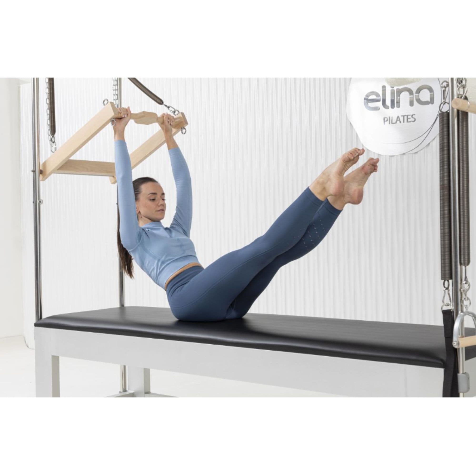 Elina Pilates Classic Aluminium Cadillac Trapeze with Accessories Angled View With A Women Performing A Pilates Exercise And Brand Name In The Background