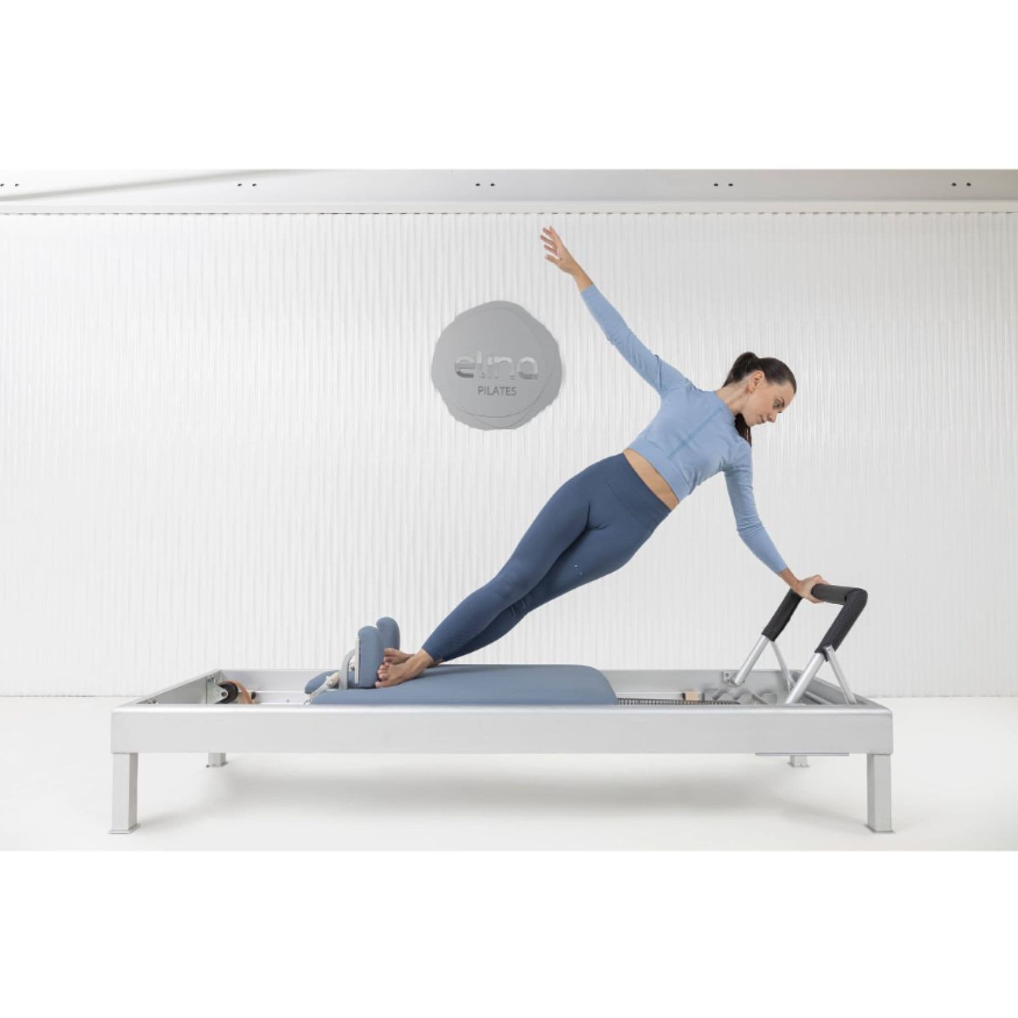 Elina Pilates Classic Aluminium Reformer 86 Inches  With A Woman Performing Exercise While One Hand Raise And The Other Is Holding At The Footbar