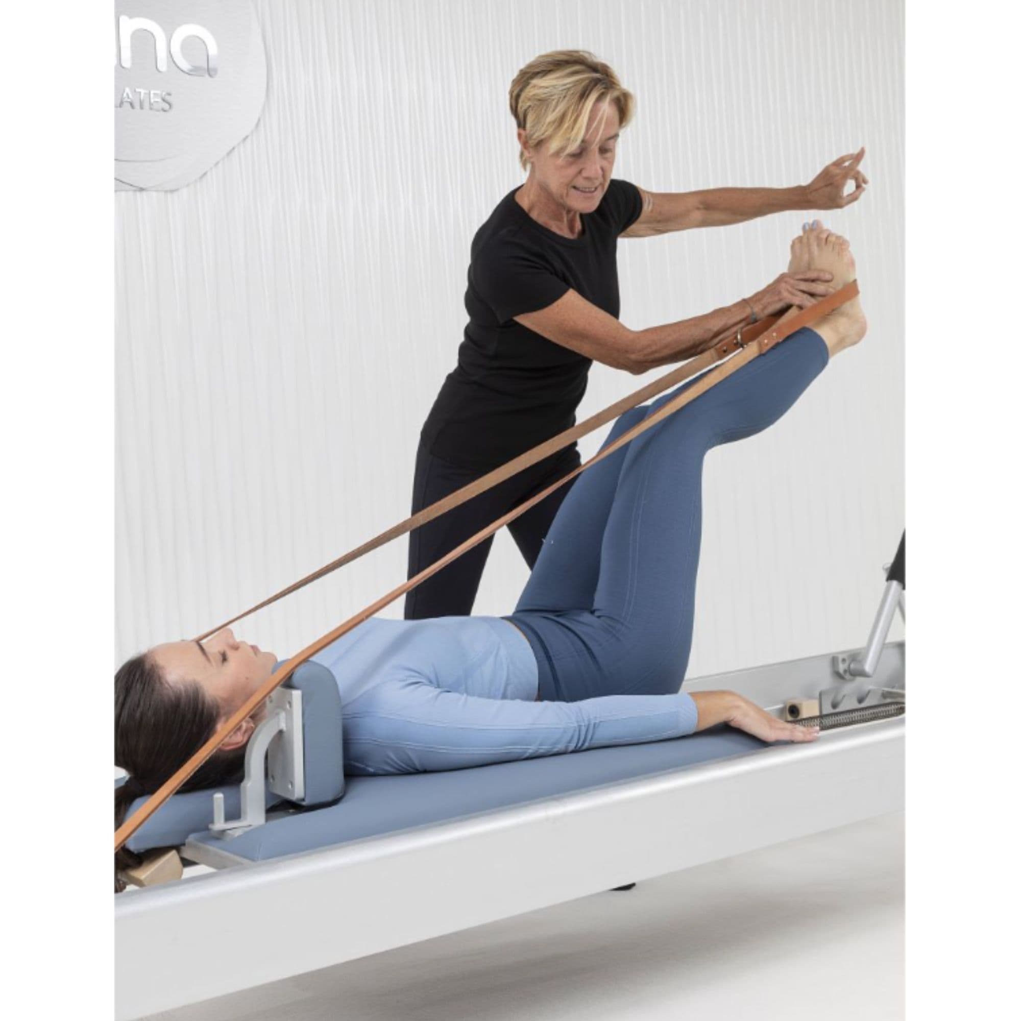 Elina Pilates Classic Reforming 86 Inches With An Older Woman Assisting The Young Girl While Performing The Exercise