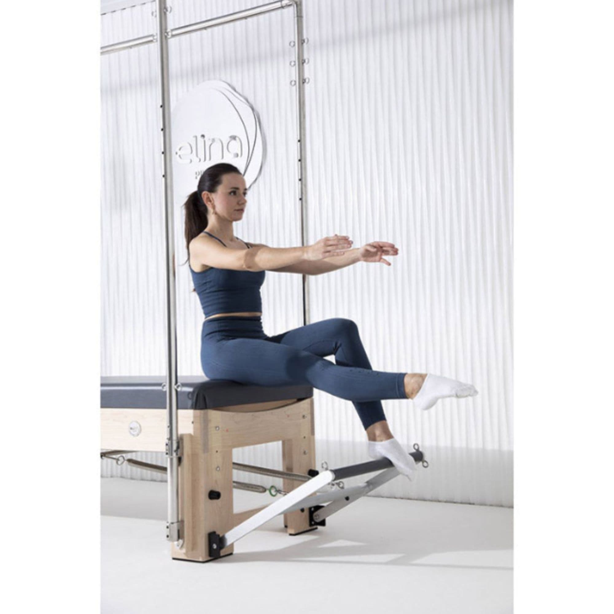 Elina Pilates Elite Cadillac Reformer Angle View With A Woman Performing Seated Pilates Movement