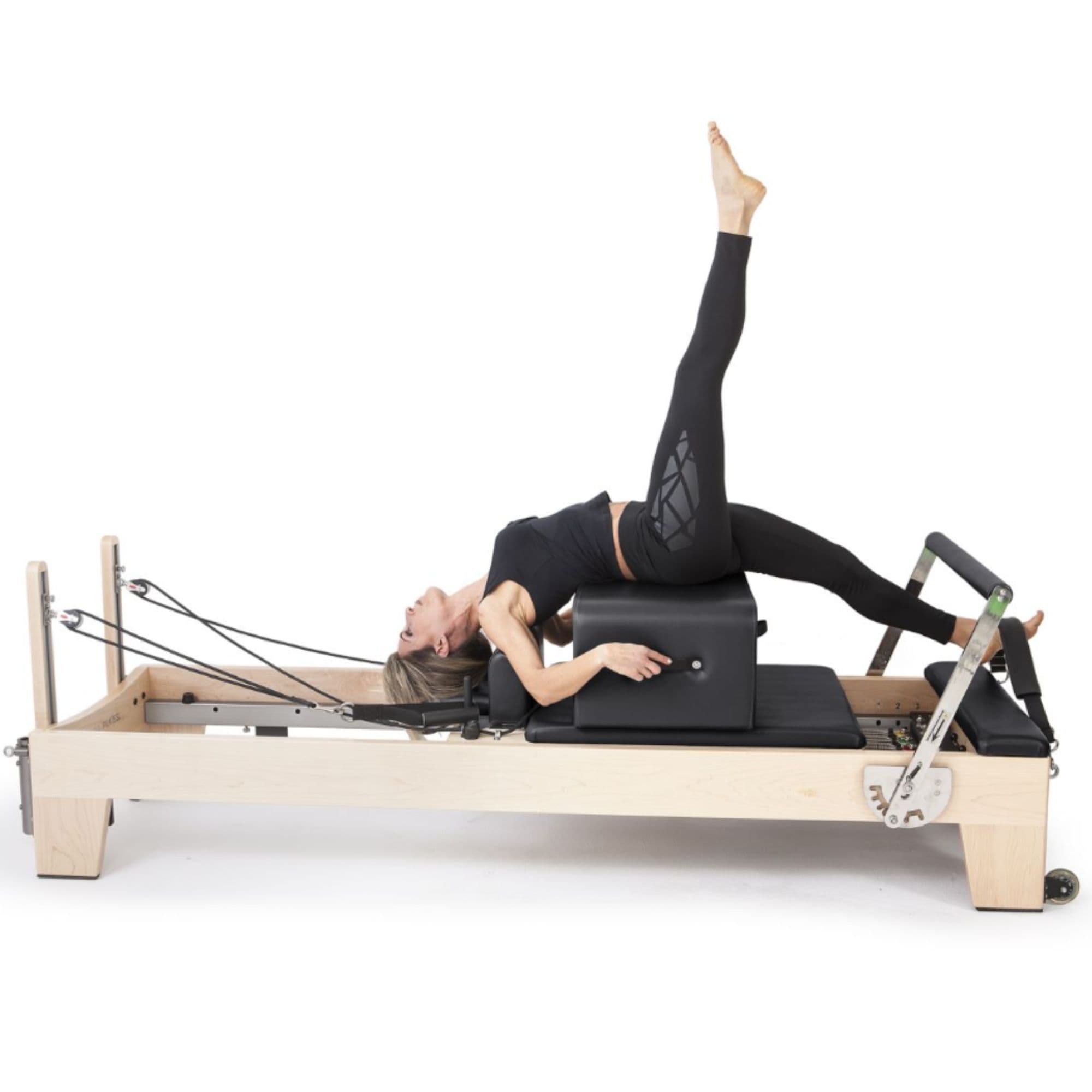 Elina Pilates Elite Wood Reformer Bundle Black Variant With A Woman Lying Down While Raising Her Right Leg