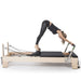 Elina Pilates Elite Wood Reformer Bundle Black Variant With A Woman Performing A Front Bend Exercise