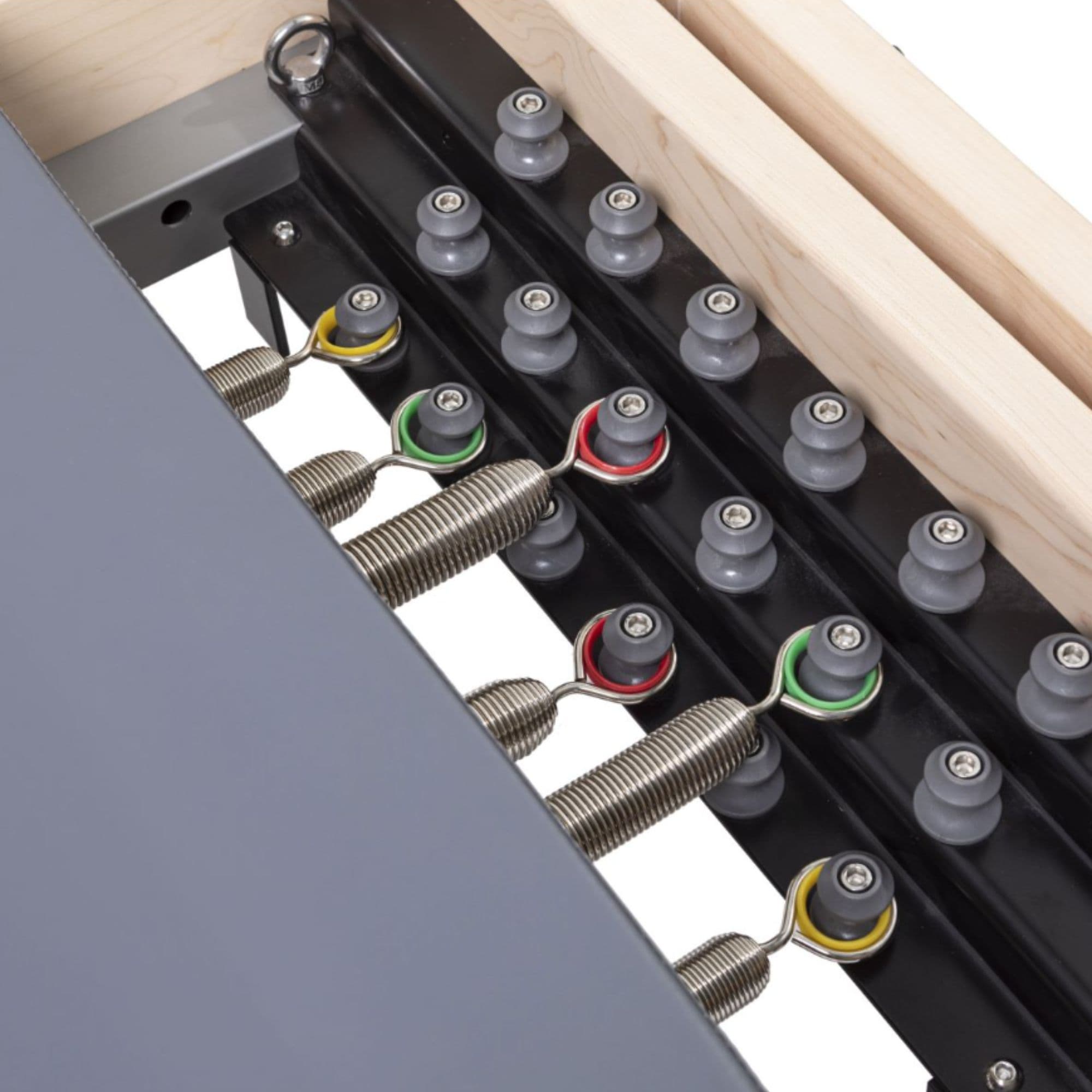 Elina Pilates Master Instructor Physio Reformer Close-Up View Of Color Coded Spring Resistance Controls On White Background