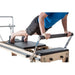 Elina Pilates Master Instructor Wood Reformer With A Man Performing A Push-up Exercise On Footbar
