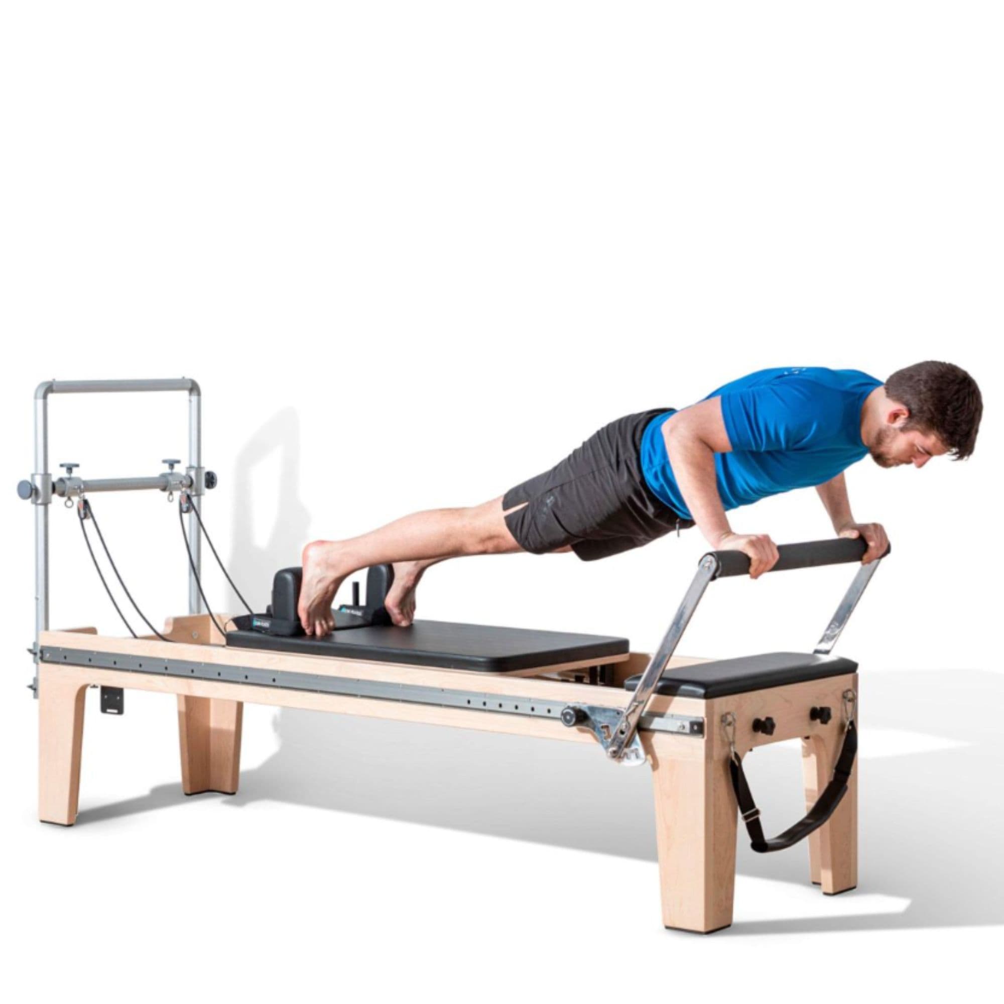 Elina Pilates Physio Reformer Master Instructor With A Man Performing A Push Up Exercise Using A Footbar