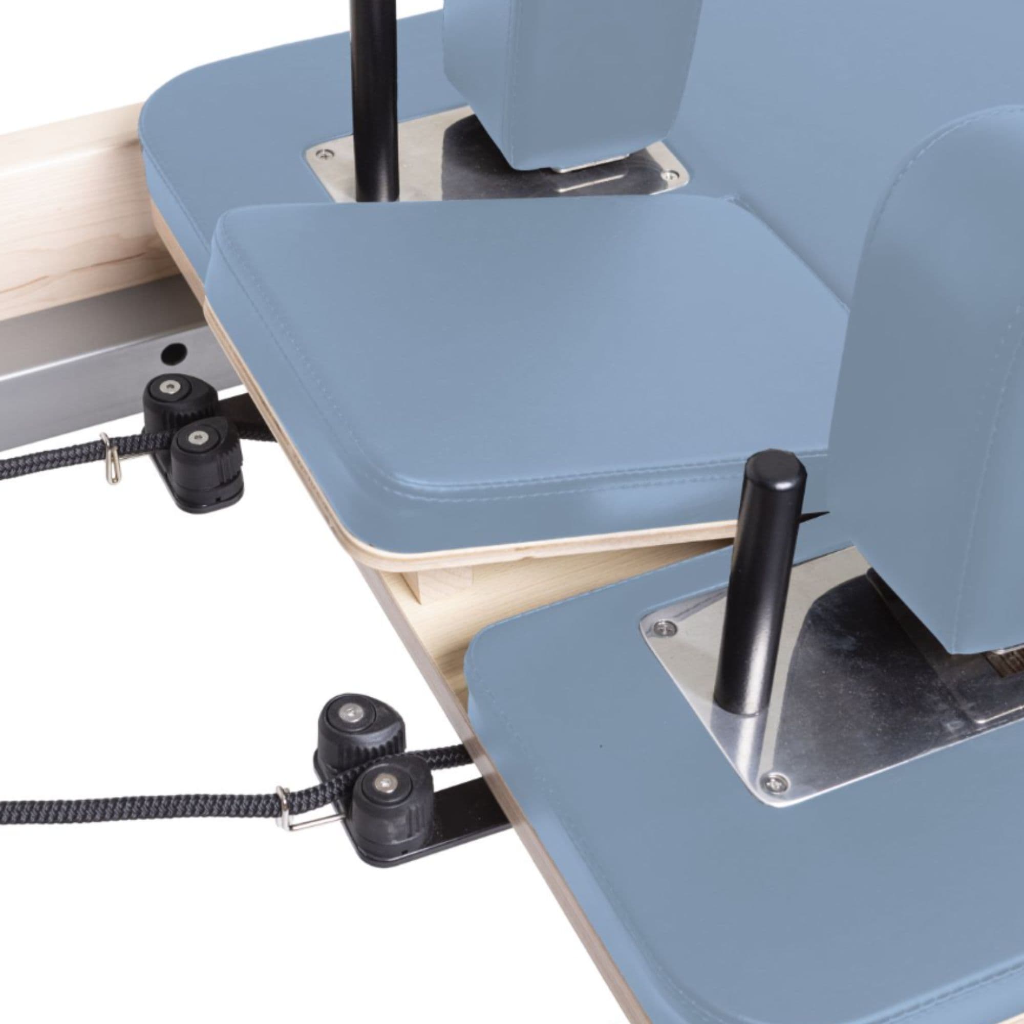 Elina Pilates Physio Reformer Master Instructor with Tower Close-Up View Of Reformer Rope Guide Pulleys On Ocean Blue Upholstered Bed