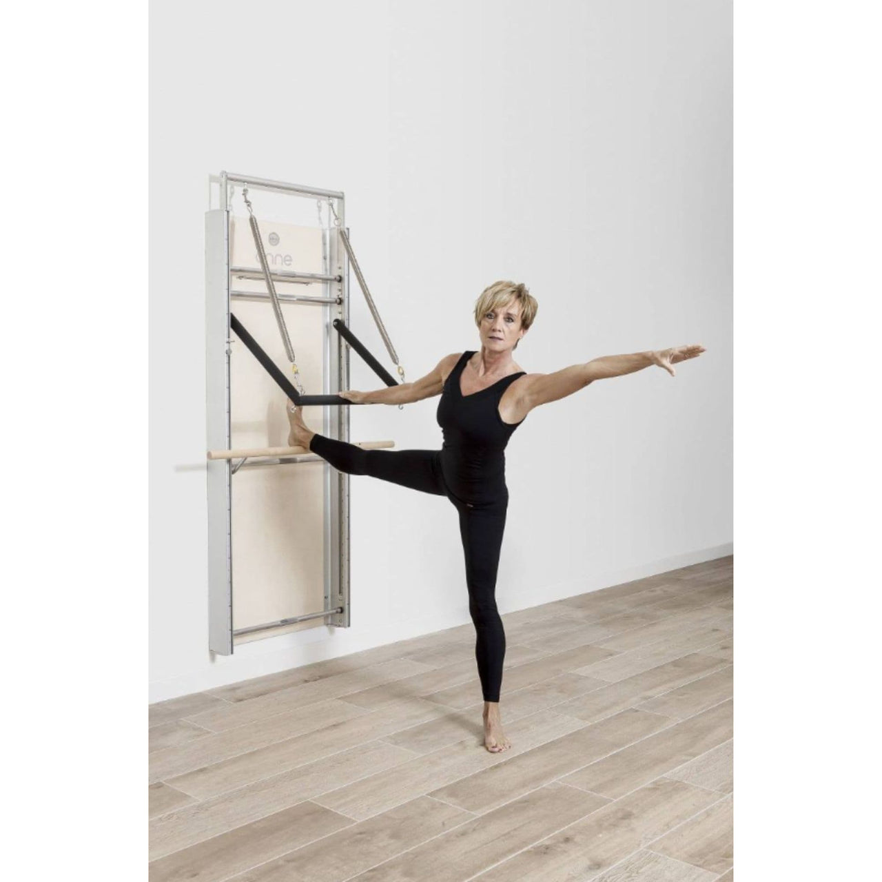 Elina Wall Board ONNE With A Woman Performing Standing Side Leg Stretch Exercise