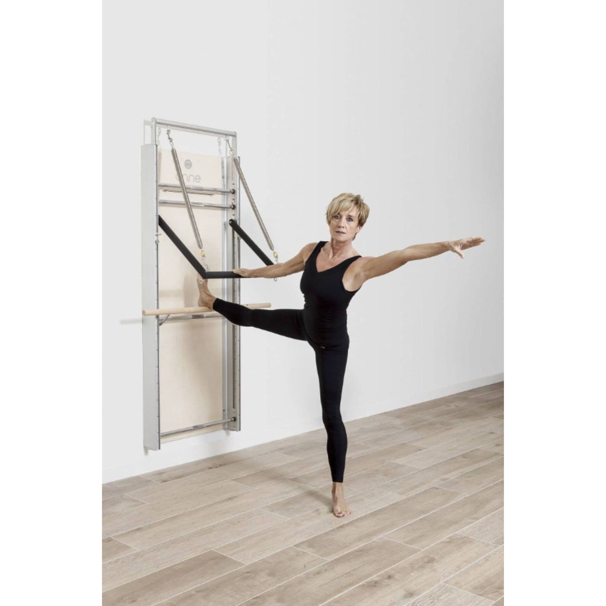 Elina Wall Board ONNE With A Woman Performing Standing Side Leg Stretch Exercise