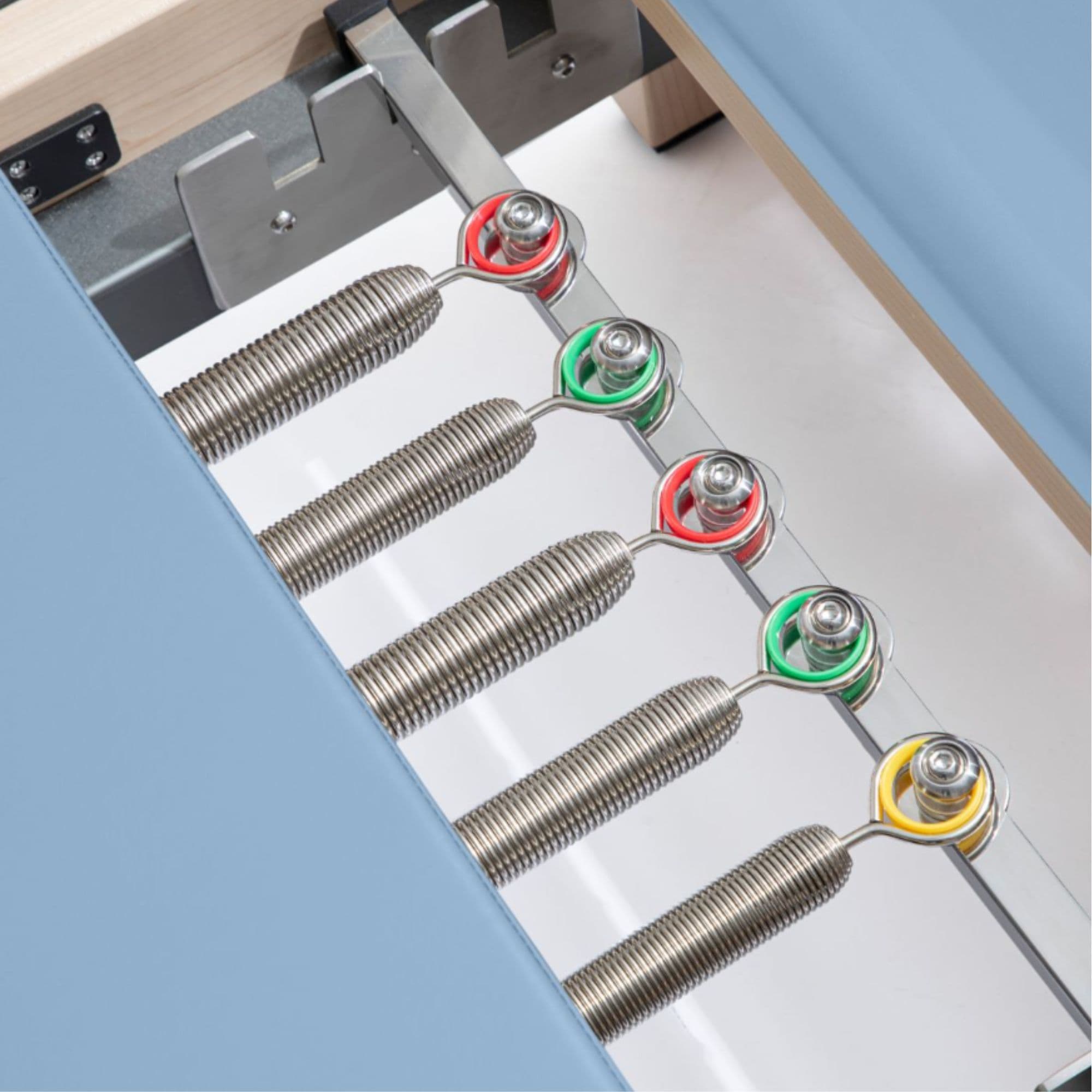 Elina Wooden Reformer Lignum with Tower Close-Up View Of Color Coded Spring Resistance Controls On White Background