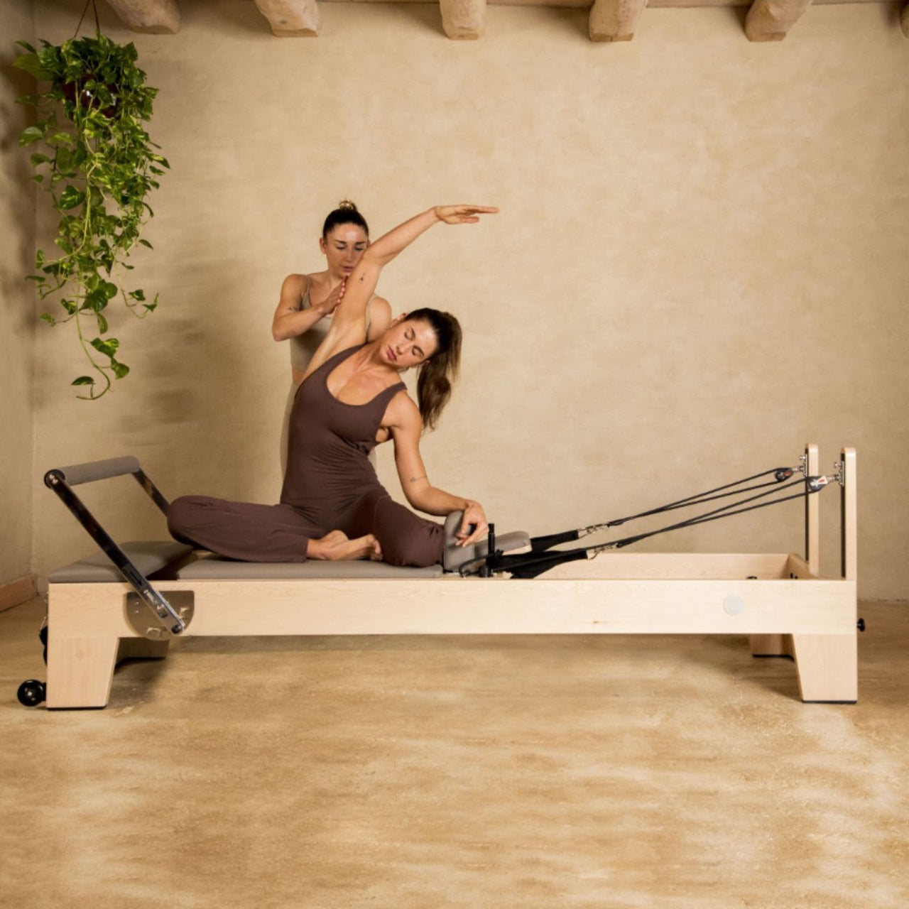 Elite Wood Reformer Gray Variant With Woman Demonstrating Pilates And With Instructor