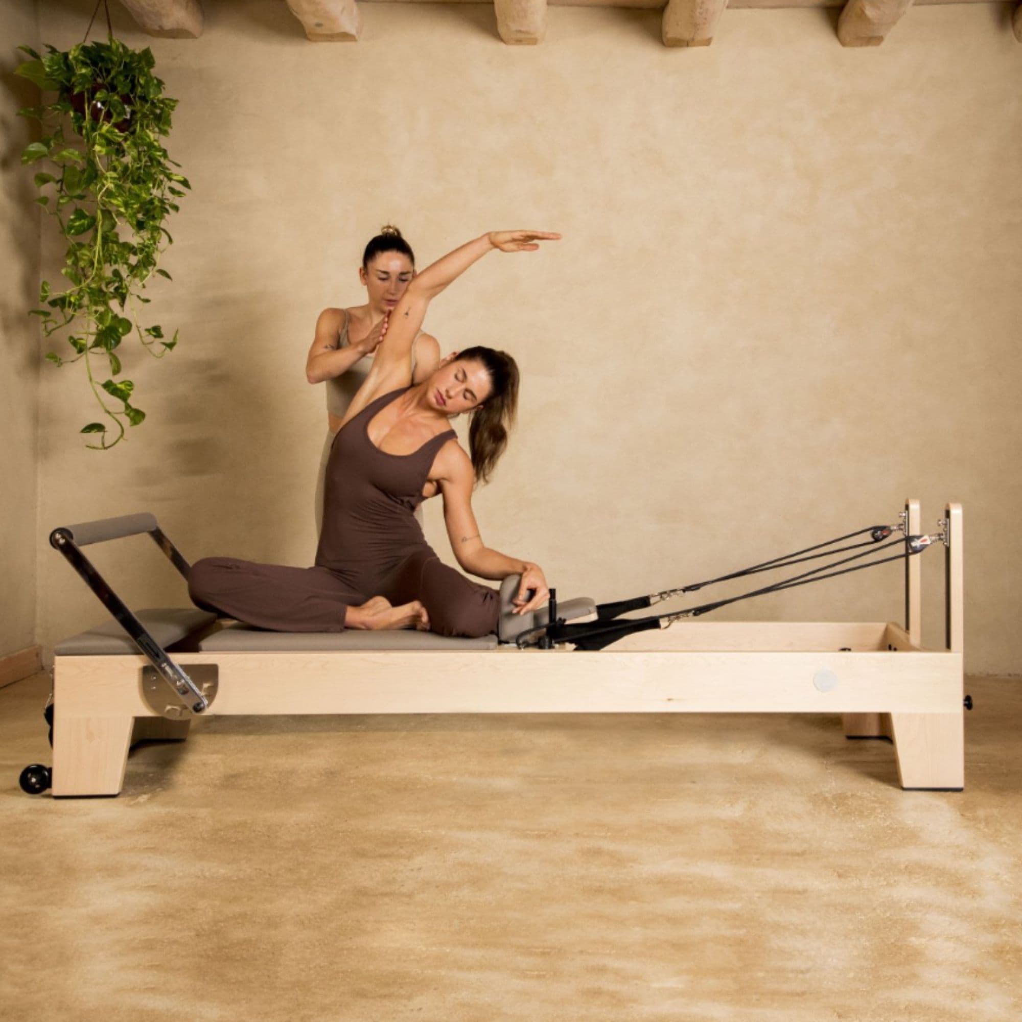 Elite Wood Reformer Gray Variant With Woman Demonstrating Pilates And With Instructor