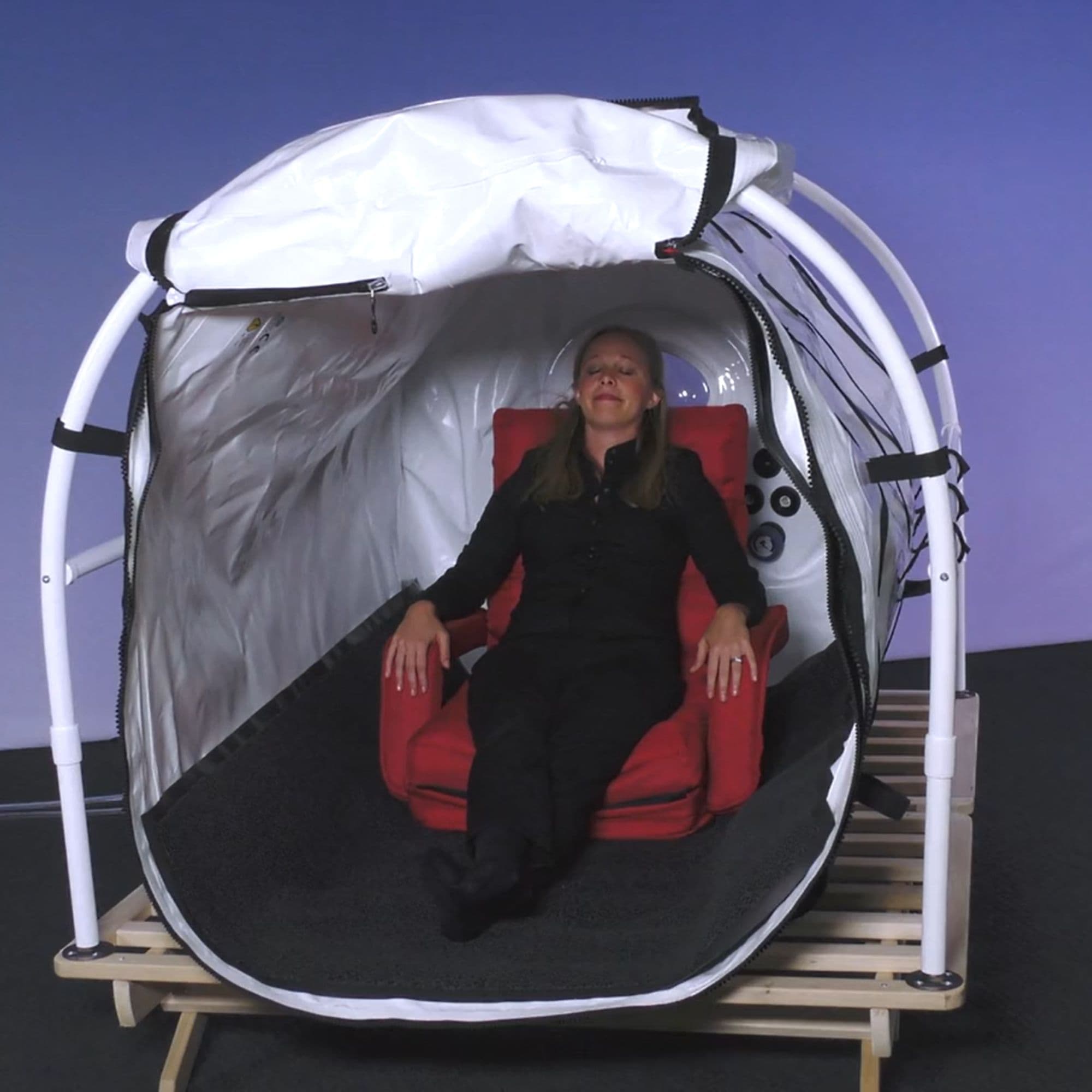 Grand Dive Pro Chamber With Optional Platform Front View With Woman Reclining In A Red Chair