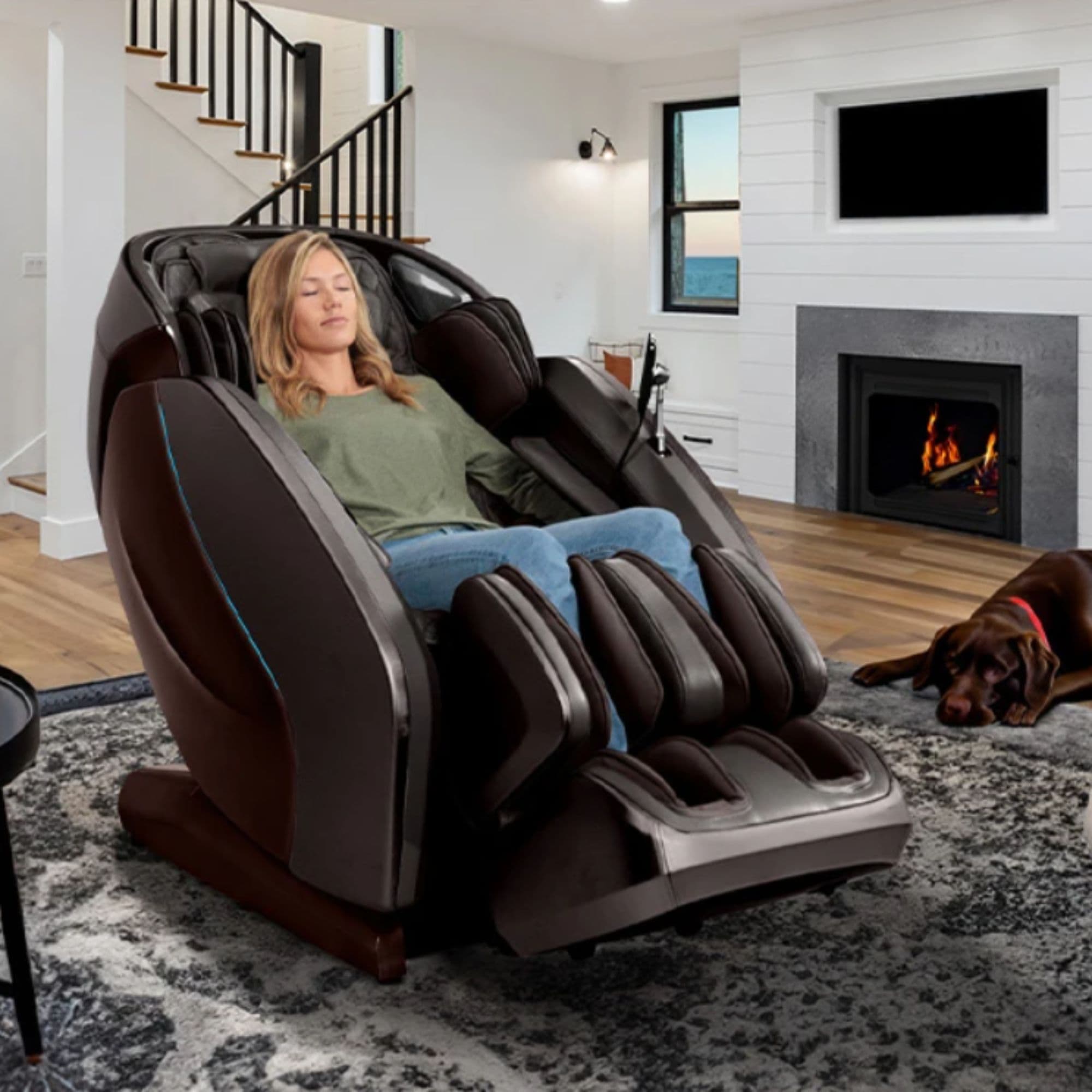 Hatsumei M900 4D AI Massage Chair Brown VAriant Front Angled Lifestyle View Of A Woman Relaxing In A Pet-Friendly Living Room With A Fireplace