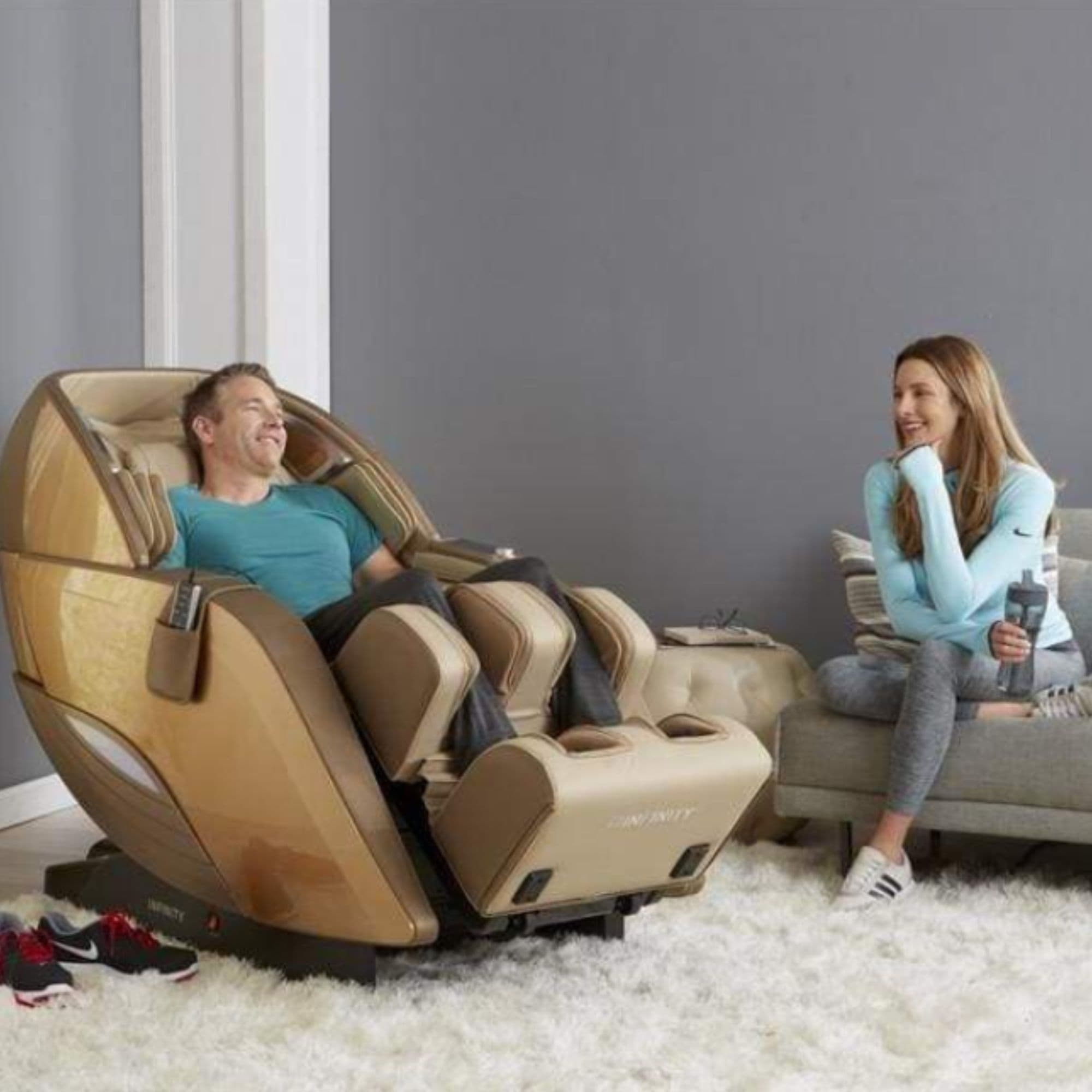 Infinity Dynasty 4D Chair CPO Front Angled View With A Man And A Woman Chatting On A Cozy Living Room