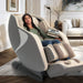 Kyota Joubu M880 4D Massage Chair Gray-Tan Variant Front Angled View Of A Woman Relaxing In A Modern Living Room