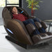 Kyota Yutaka M898 4D Massage Chair Brown Variant Front Angled View Of A Man Relaxing In A Modern Living Room With Bamboo In The Background