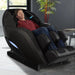 Kyota Yutaka M898 4D Massage Chair Certified Pre-Owned Black Variant Front Angled View Of A Man Relaxing In A Modern Home Setting With A Bamboo Plant