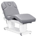 Luxi Quad-Motor Medical Spa Bed Front Angled View Of Gray Color With Semi-Folded Leg Section And Remote Control On White Background