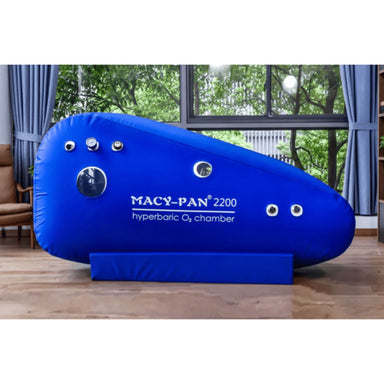 Macy-Pan ST2200 Soft Sitting Hyperbaric Chamber Side View Of Blue Color By Large Windows With Greenery Views