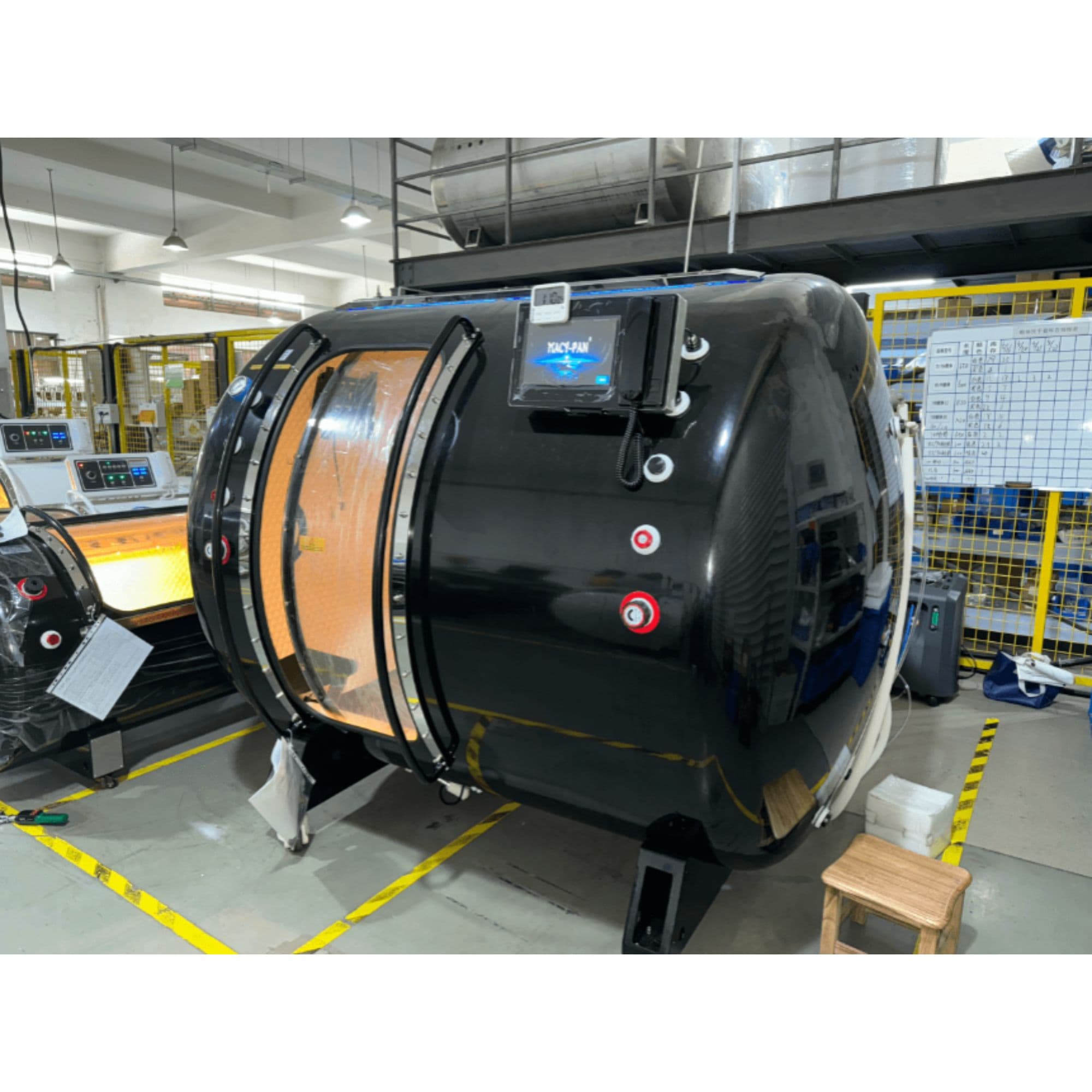 Macy Pan HE5000 Multiplace Hyperbaric Chamber – 5 Person Hard Shell 1.5–2.0 ATA Front Angle View Of Black Color In A Manufacturing Facility