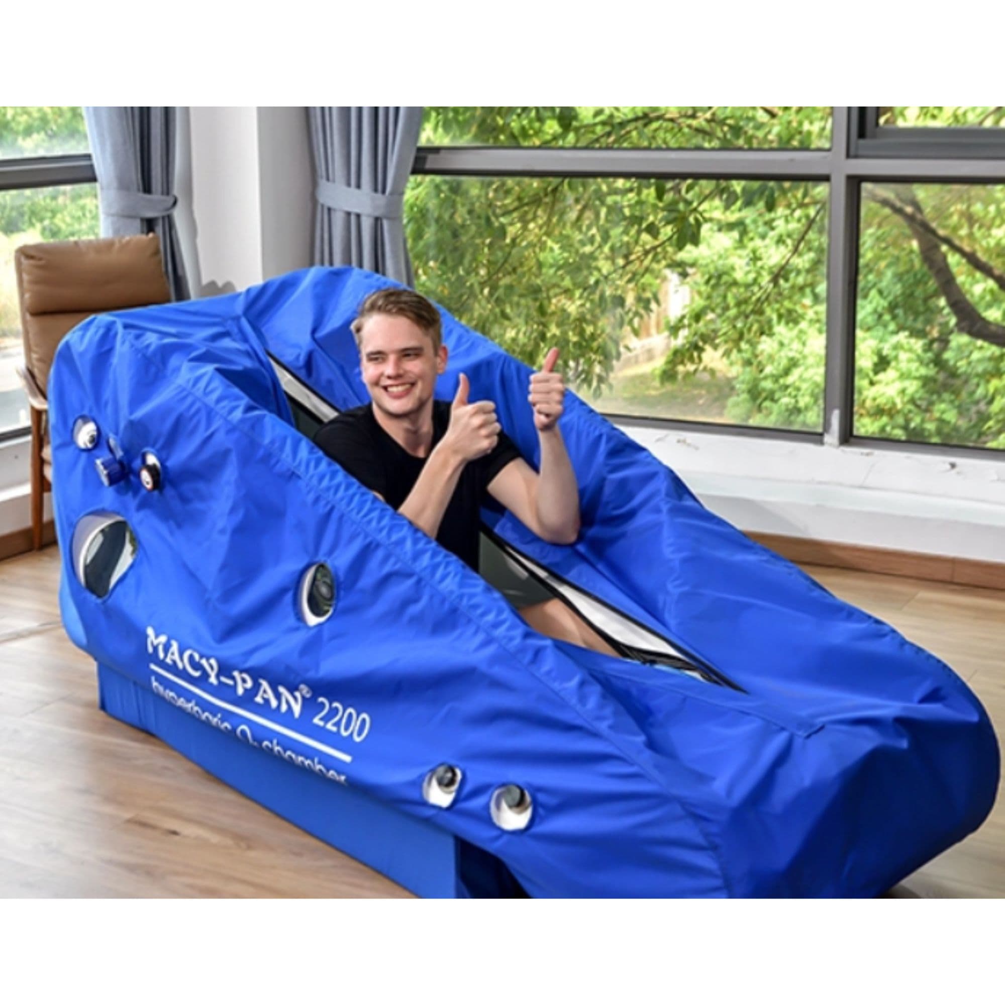 Macy Pan ST2200 Sitting Hyperbaric Chamber With A Boy Sitting Inside On A Large Glass Window Background