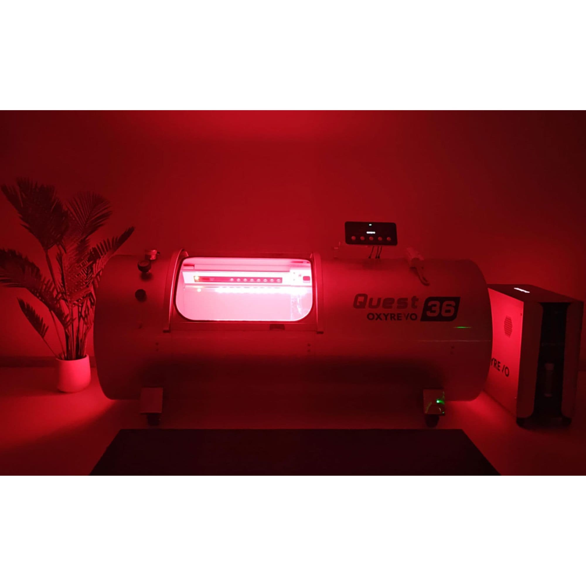 OxyRevo Quest36 2.0 ATA Hard Hyperbaric Chamber Front View With Potted Plant In A Dark Room