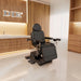 Pavo OB 4-Motors OB GYN Exam Chair with Stirrups With Natural Wooden Textured Wall In The Background