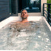 Revive Acrylic Cold Plunge And Hot Therapy Tub With Man Enjoying Cold Water Immersion In Balcony Setting