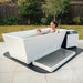 Revive Acrylic Cold Plunge With Woman Enjoying Water Immersion In Backyard Setting With Wooden Fence And Trees