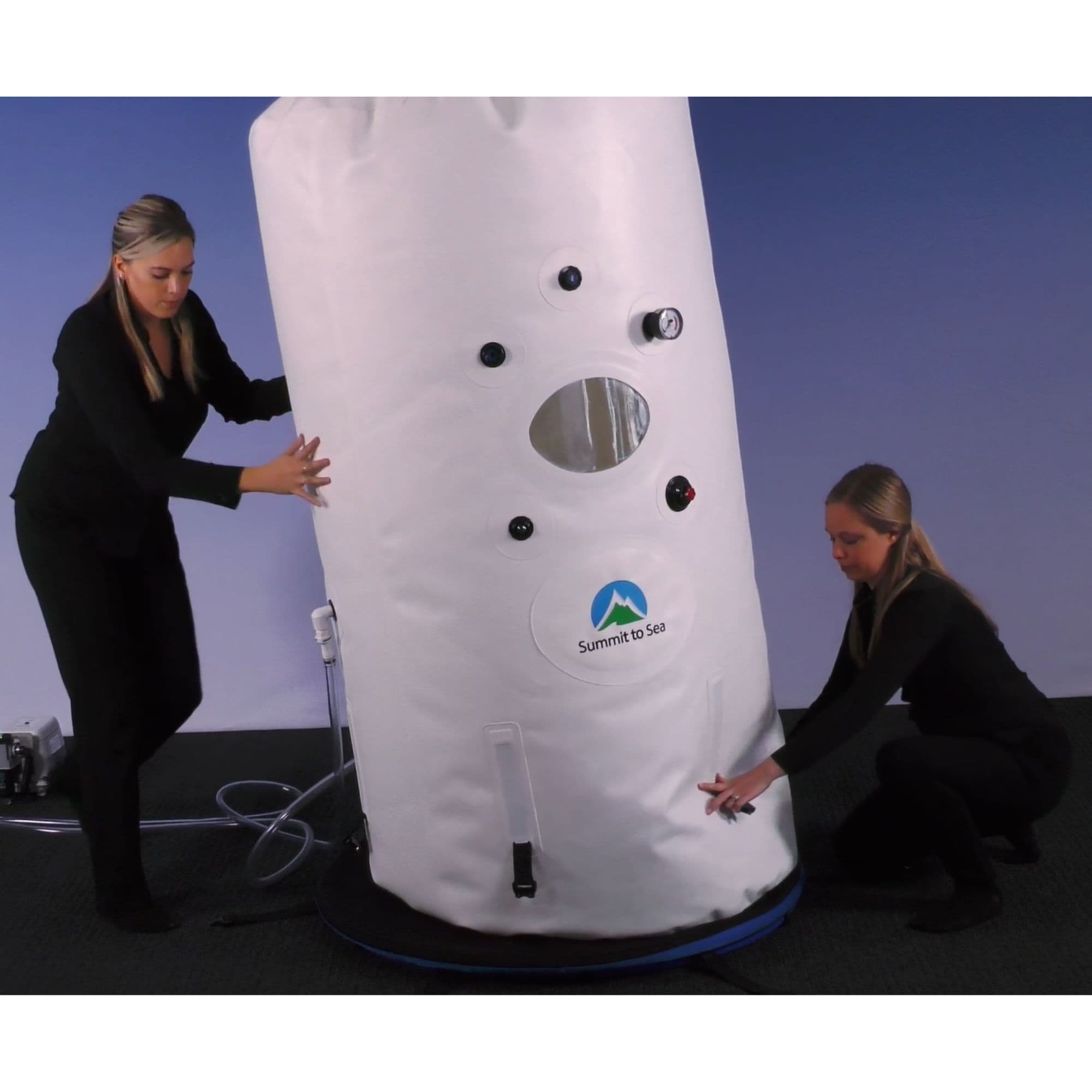 Summit to Sea Dive Vertical Hyperbaric Chamber Front View With Two Women Holding It