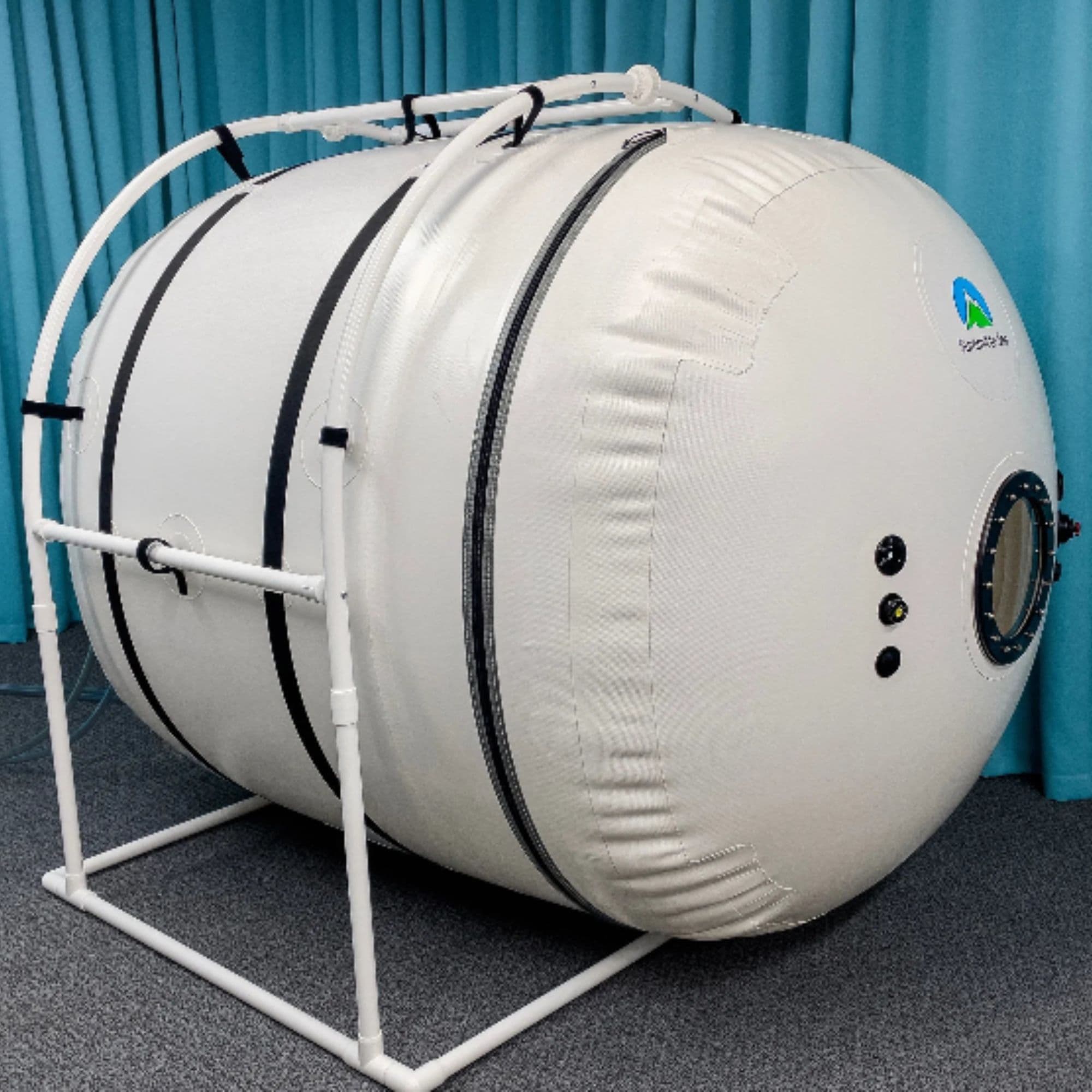Summit to Sea Grand Dive Pro Plus Short 60-Inch Hyperbaric Chamber Front Angle View With Blue Curtain In The Background And Gray Carpet Floor