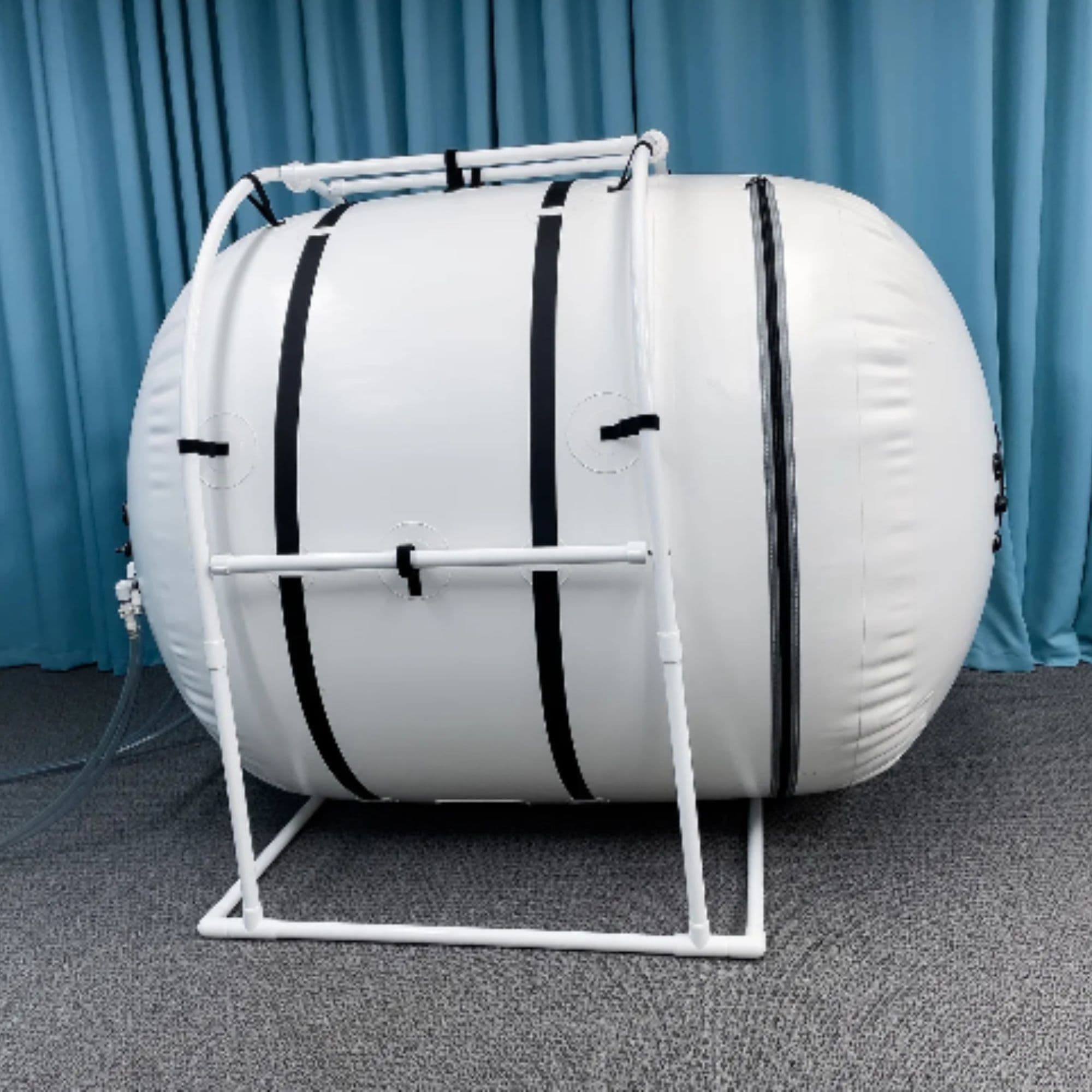 Summit to Sea Grand Dive Pro Plus Short 60-Inch Hyperbaric Chamber Side View With Blue Curtain In The Background And Gray Carpet Floor