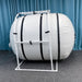 Summit to Sea Grand Dive Pro Plus Short 60-Inch Hyperbaric Chamber Side View With Blue Curtain In The Background And Gray Carpet Floor