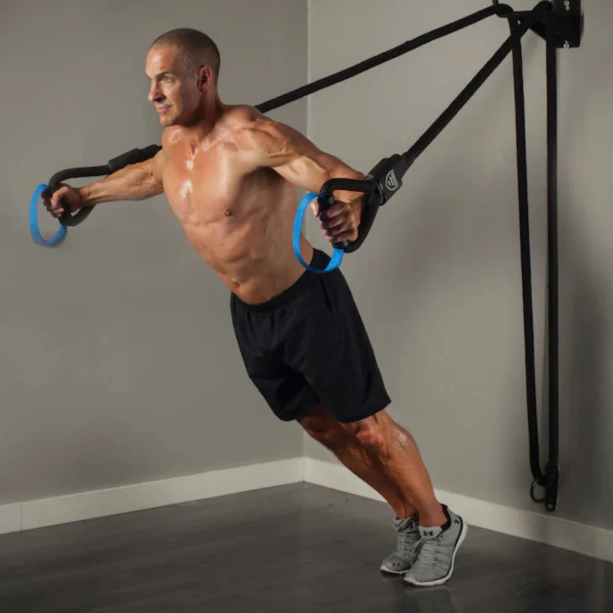 The Abs Company Battle Rope Suspension System With A Man Performing A Chest Fly Exercise