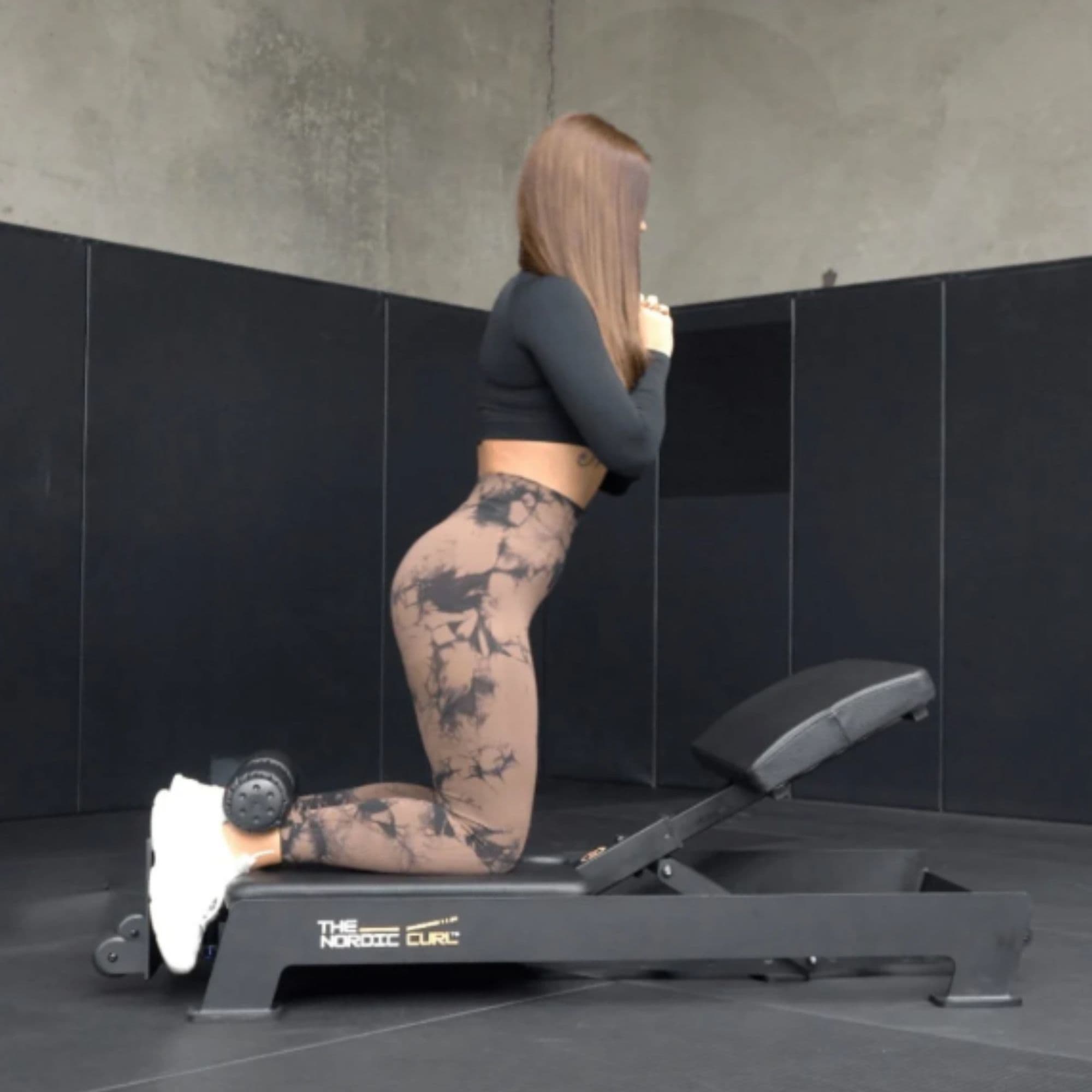 The Abs Company Nordic Curl Machine Side View Of The Woman Performing The Lower Body Strength Training