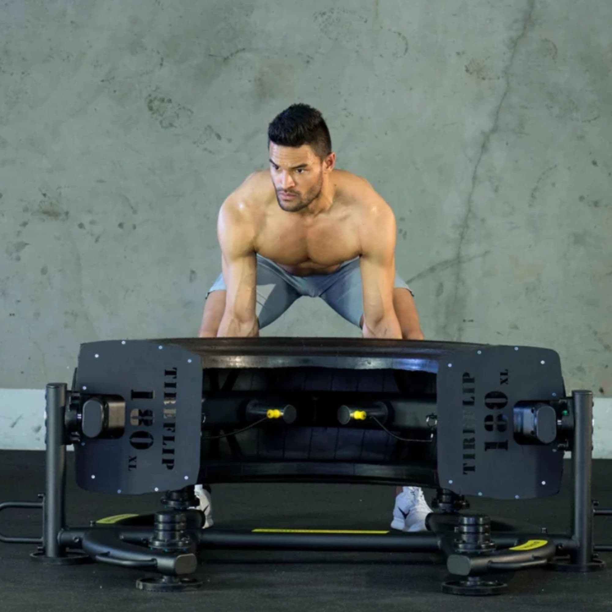 The Abs Company TireFlip 180 With A Man Preparing To Flip