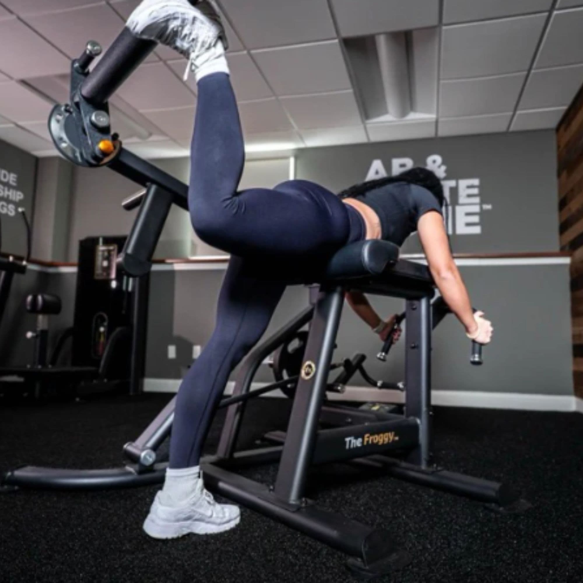 The Froggy Abs Company With A Woman Performing A Single-Leg Prone Leg Curl