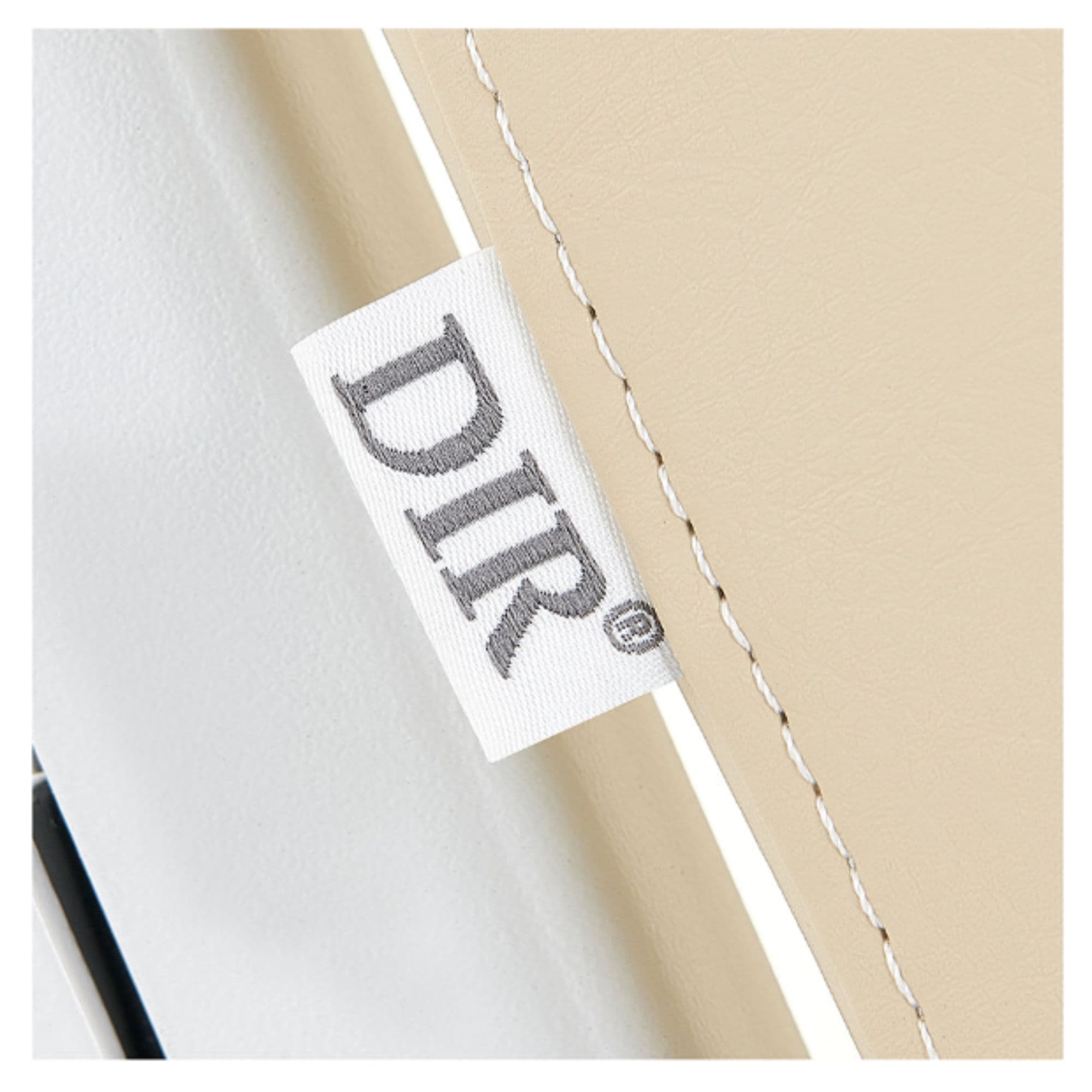 Tranquility 4-Motors Electric Medical Spa Treatment Table Close-Up View Of Beige Upholstery With Brand Name And Stitching On White Background