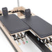 Twin Pilates Reformer Detailed View Showing Split Carriage And Color-coded Spring On White Background