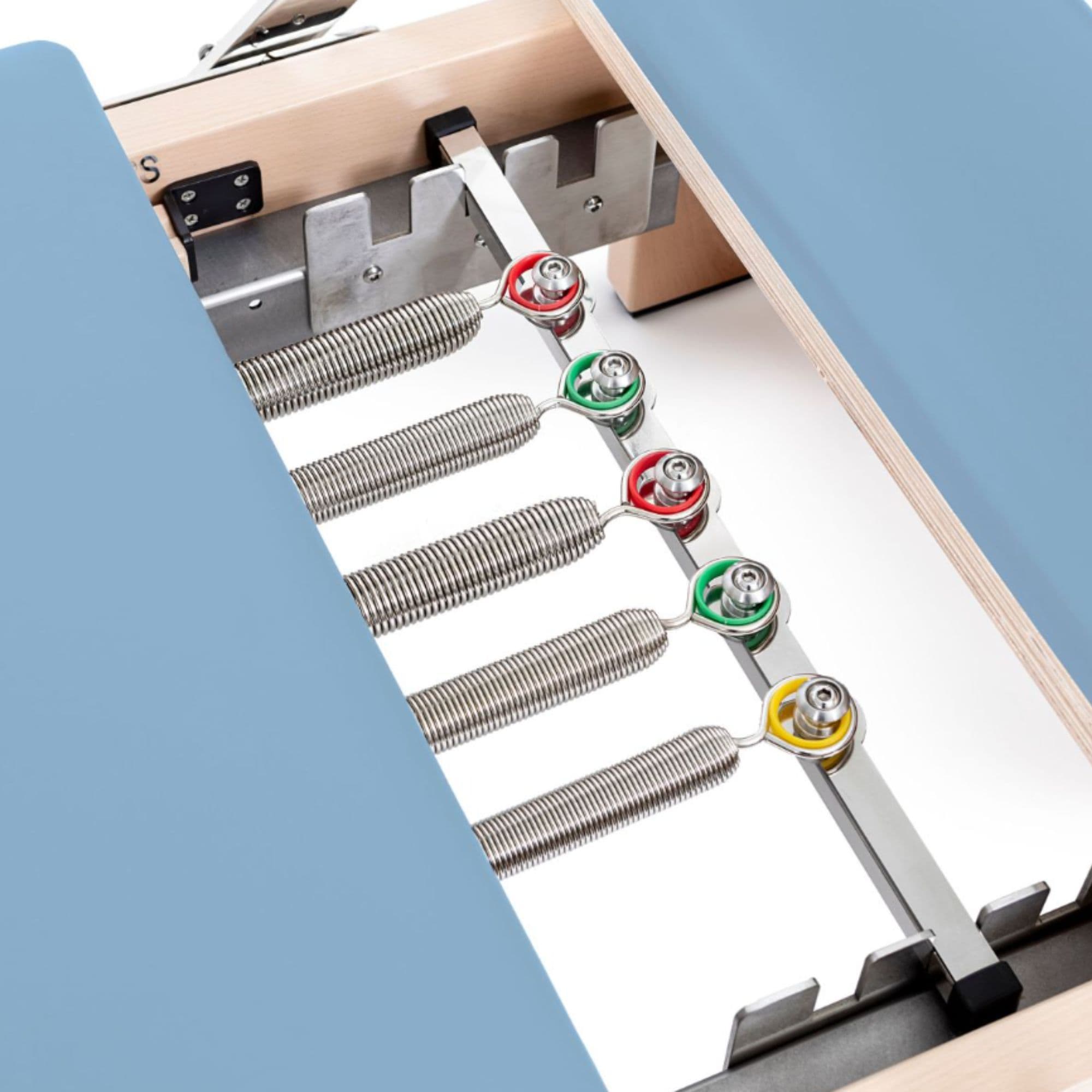 Wooden Reformer Lignum Close-Up View Of Color Coded Spring Resistance Controls On White Background