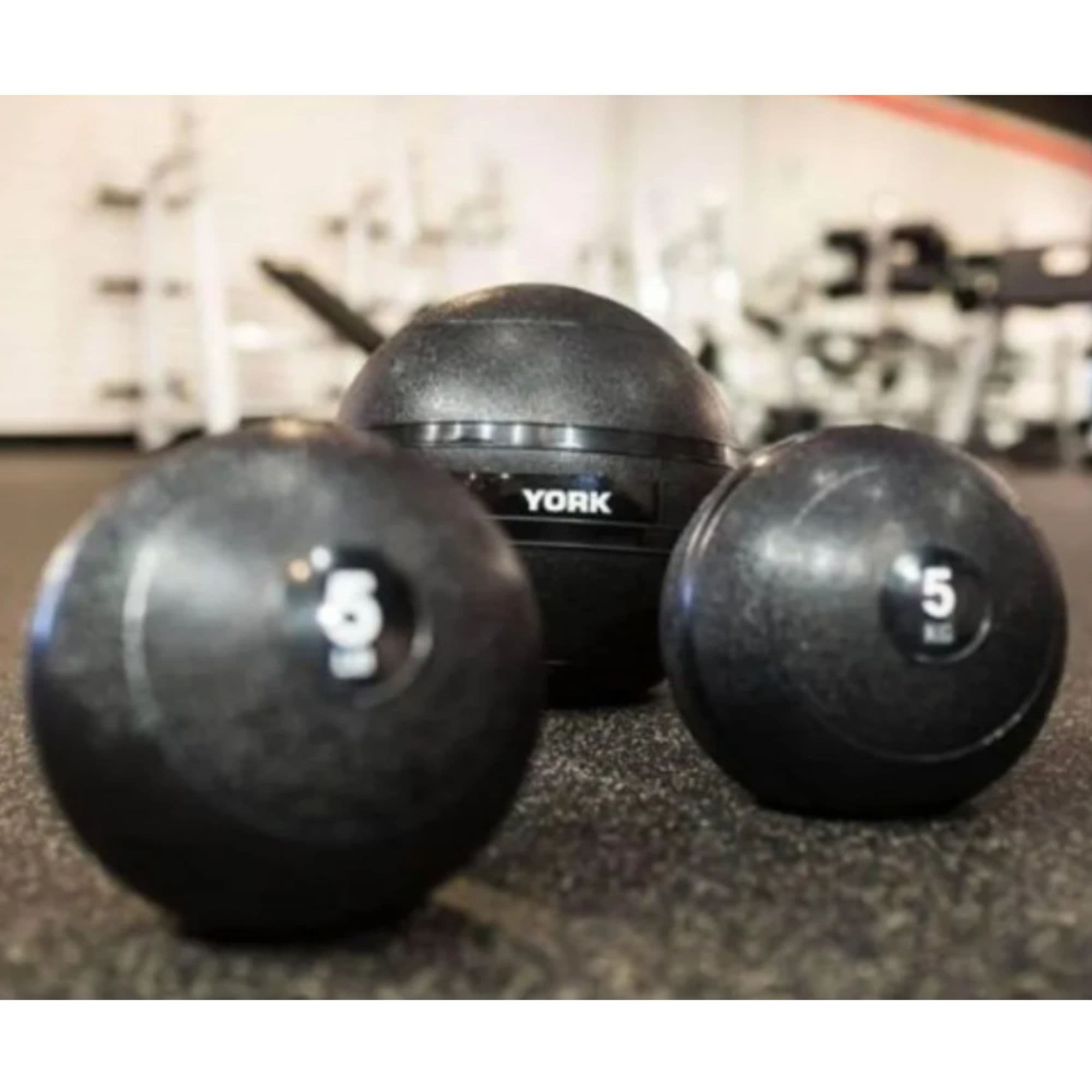 York Barbell Slam Balls Set Detailed View Of 5KG On Gym Background